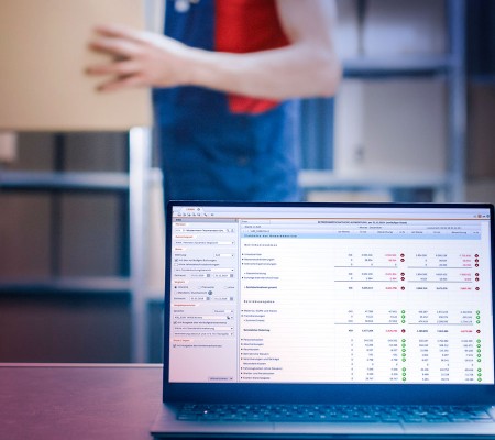 Ein aufgeklappter Laptop zeigt die Benutzeroberfläche der Simba Software, geöffnet ist die die Funktion "Jahresabschluss"